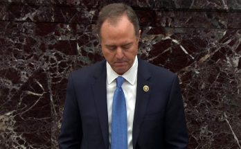 Man in suit with bowed head before marble wall