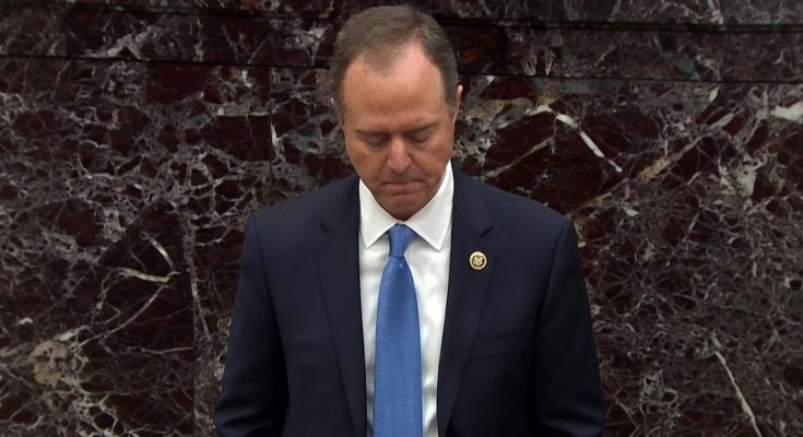 Man in suit with bowed head before marble wall