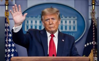 Trump waving from presidential podium