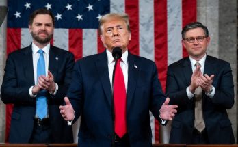 Donald Trump speaking at podium with American flag