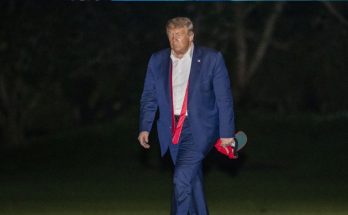Trump walking at night with hat