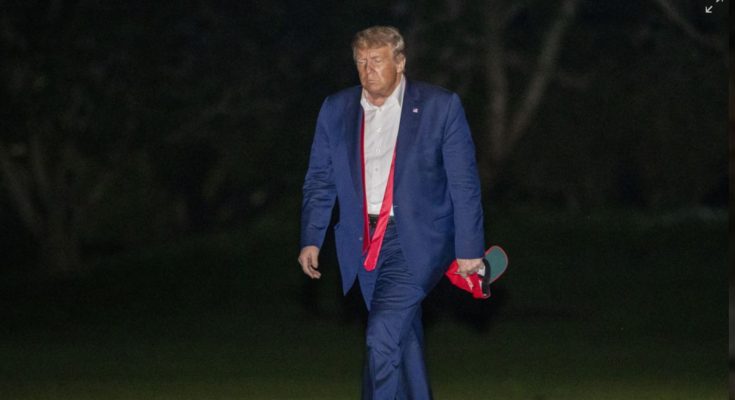 Trump walking at night with hat