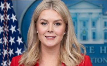 karoline Leavitt in red blazer at White House press briefing with American flag backdrop