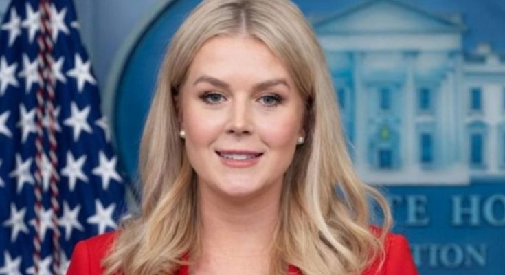 karoline Leavitt in red blazer at White House press briefing with American flag backdrop