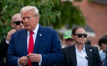 Donald Trump walking outdoors in suit