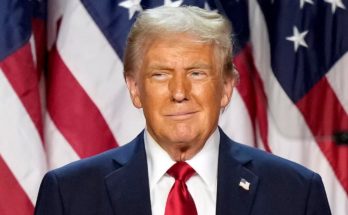 Donald Trump in front of American flags