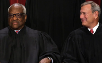 two Supreme Court justices in black robes seated side by side at a formal event