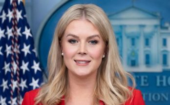 Pam Bondi smiling in red jacket