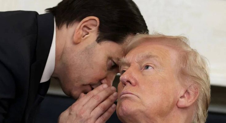 man in suit leans close to whisper in another man's ear during indoor meeting