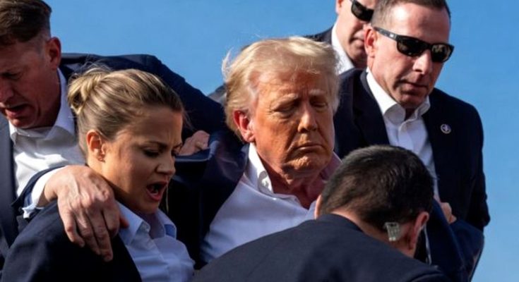 Donald Trump escorted by security