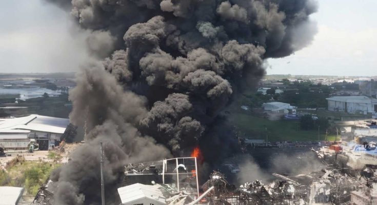 Massive explosion with black smoke over buildings
