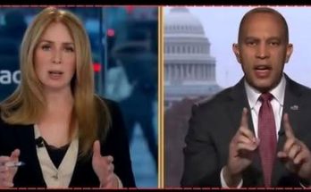 news anchors in studio, one gesturing, Capitol Building visible behind other anchor