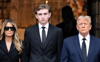 donald Trump, Melania Trump, and Barron Trump in formal black attire standing solemnly