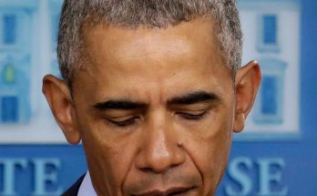 former President Barack Obama looking down with eyes closed at a White House press