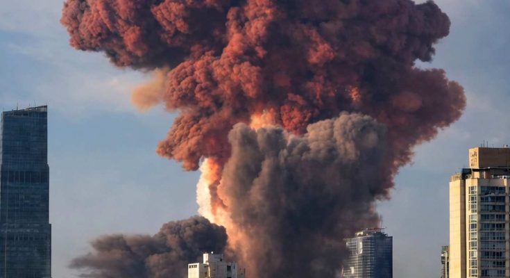 massive reddish-brown and black smoke plume rising above city skyline with modern