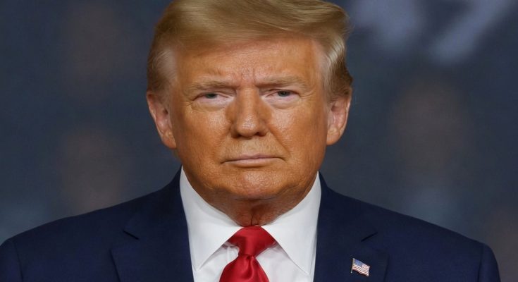 donald Trump in navy suit with red tie and American flag pin, serious expression against