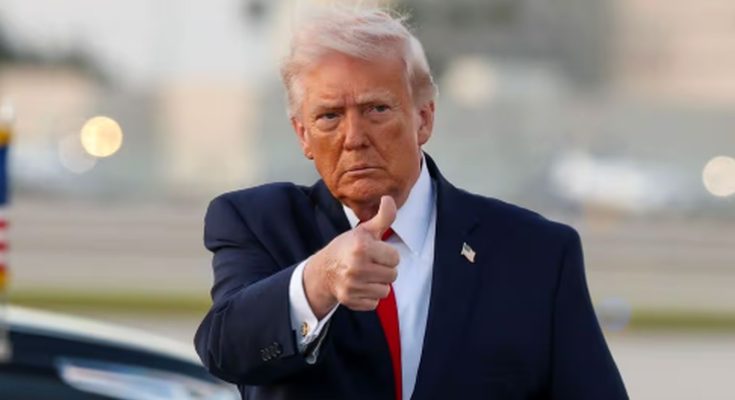 former President Donald Trump giving a thumbs-up gesture outdoors in a suit