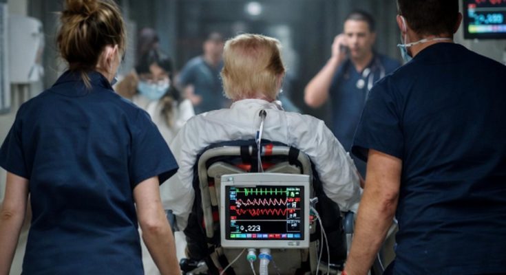 medical team rushing patient on stretcher in busy hospital corridor