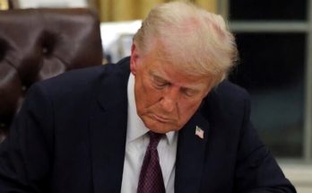 Trump signing document at desk