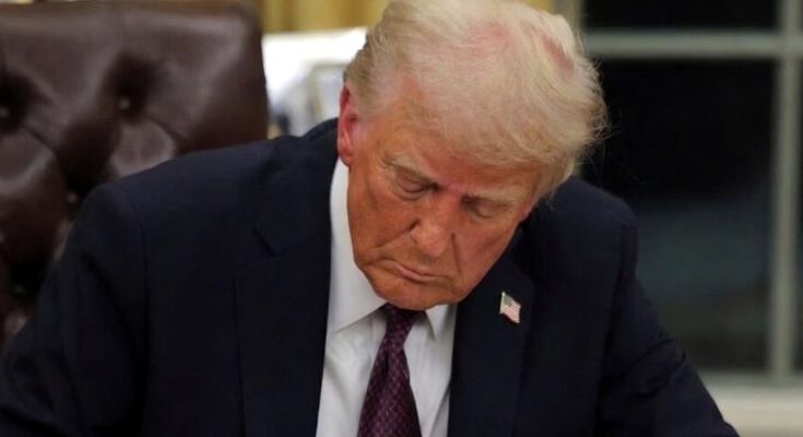 Trump signing document at desk