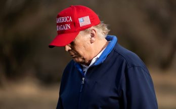 donald Trump wearing red 'Make America Great Again' cap and blue jacket outdoors