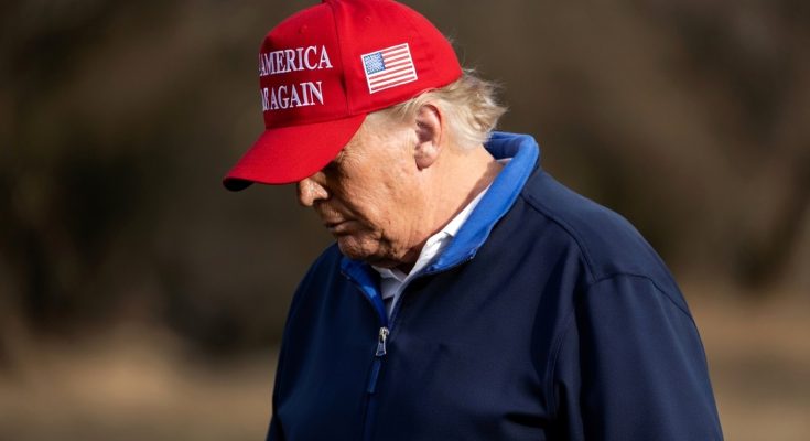 donald Trump wearing red 'Make America Great Again' cap and blue jacket outdoors