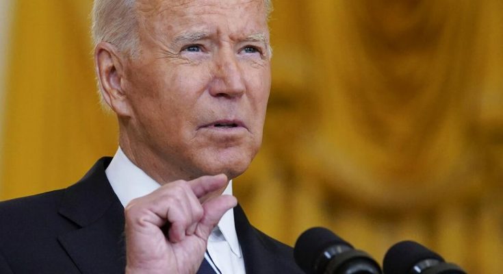 president Joe Biden speaking at podium with microphones, gesturing with finger raised